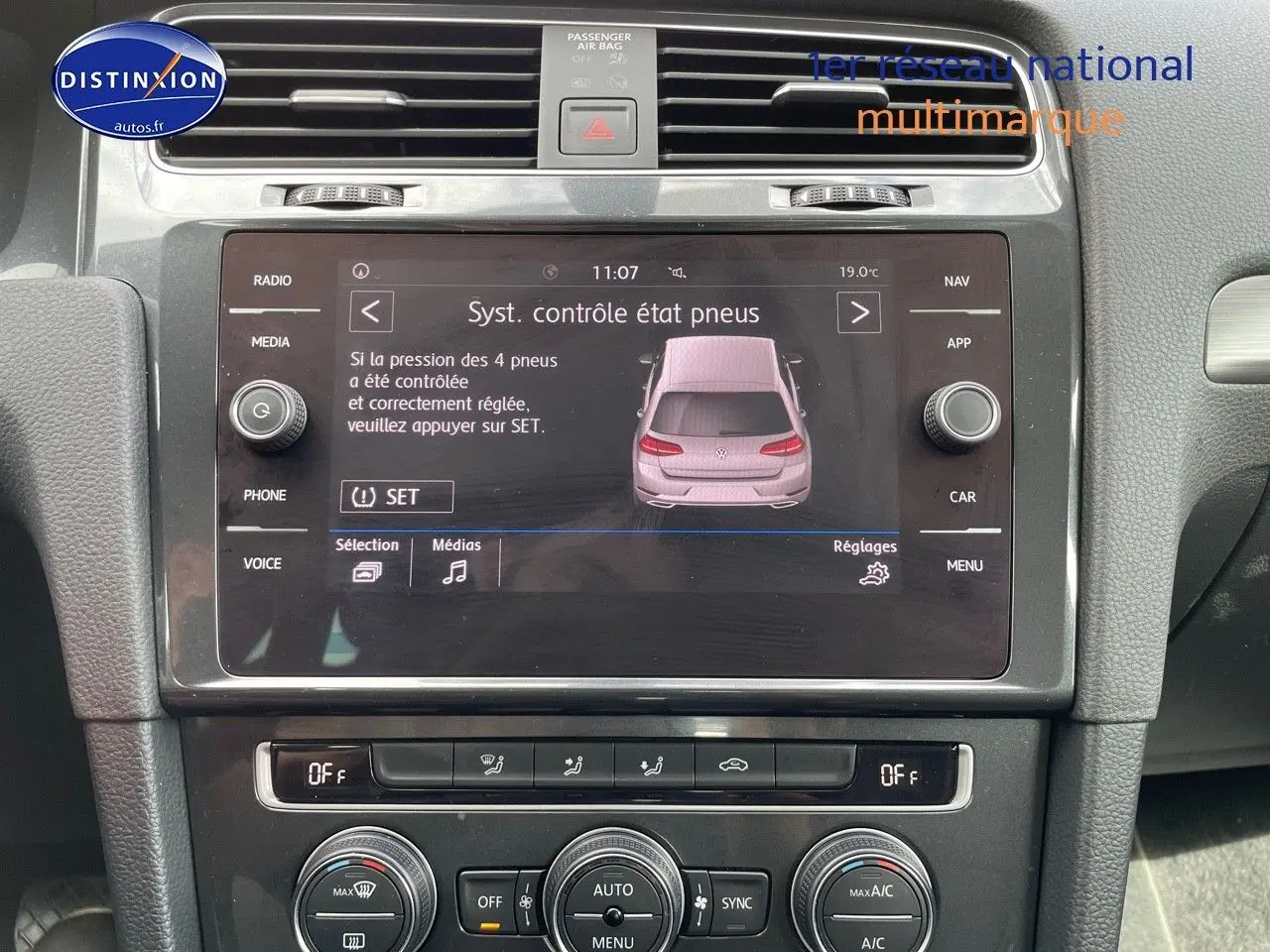 Vue rapprochée de l’écran central tactile de la Volkswagen Golf rouge, affichant le contrôle de pression des pneus.