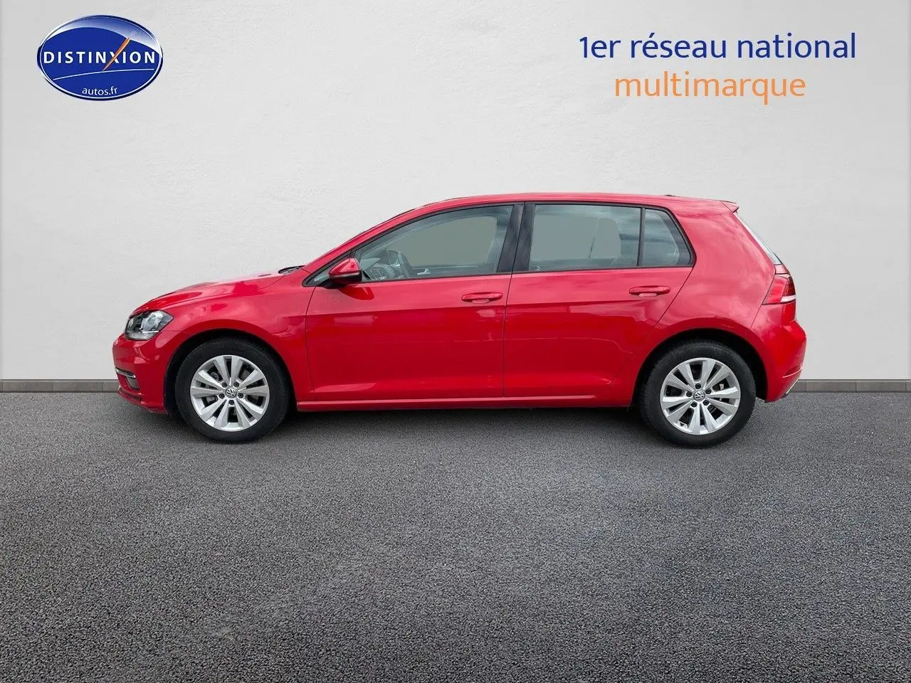 Profil droit d'une Volkswagen Golf VII rouge de 2018, avec jantes alliage et vitres teintées, sur fond neutre.