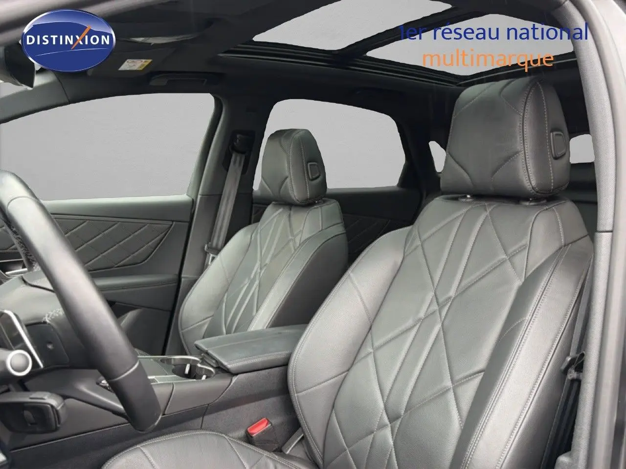 Vue intérieure sur les sièges avant en cuir noir matelassé du DS7 2024, avec toit panoramique et console centrale.