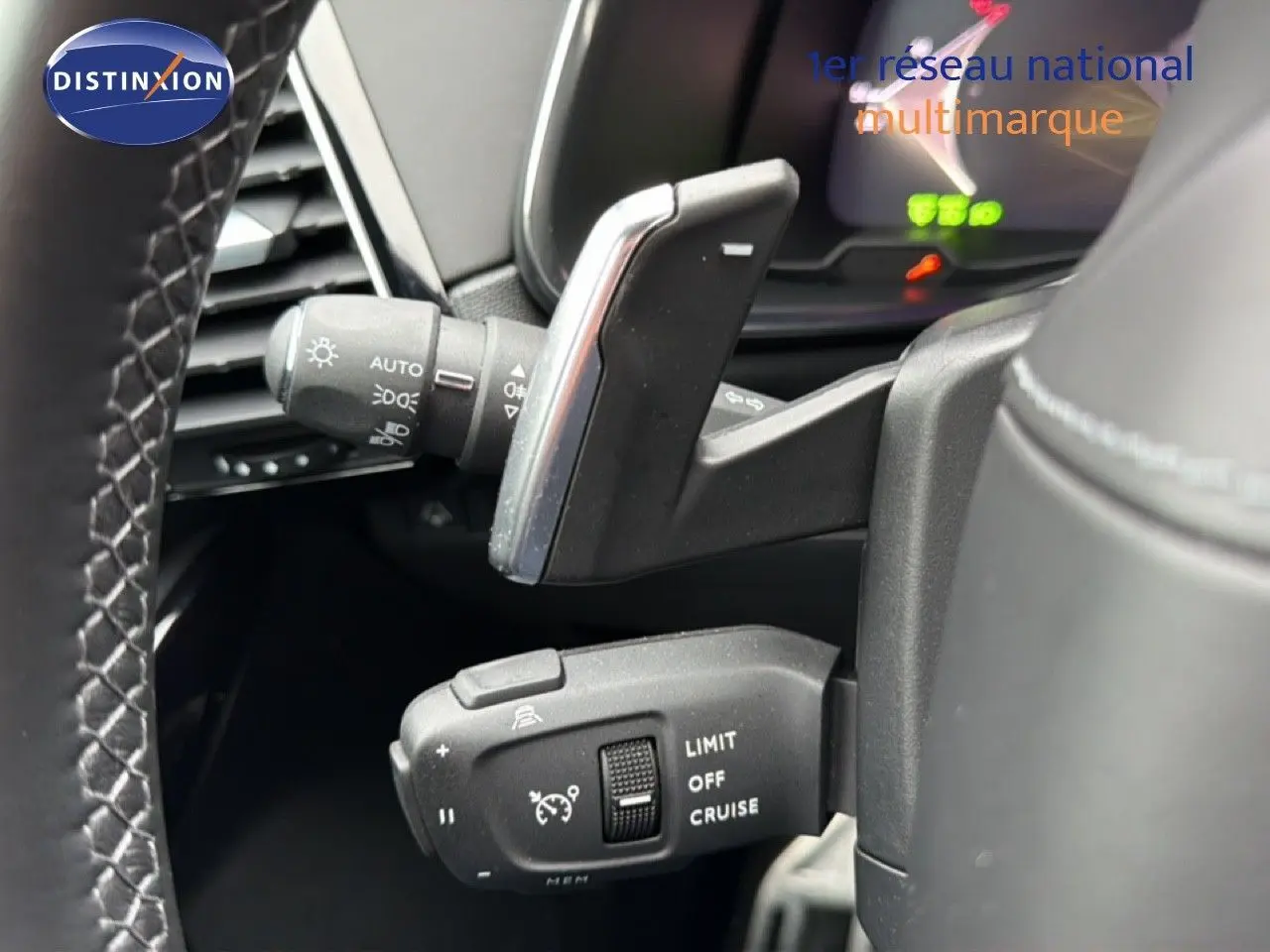 Gros plan sur les commandes au volant du DS7 2024 gris titane, montrant le régulateur de vitesse et les commandes d'éclairage.