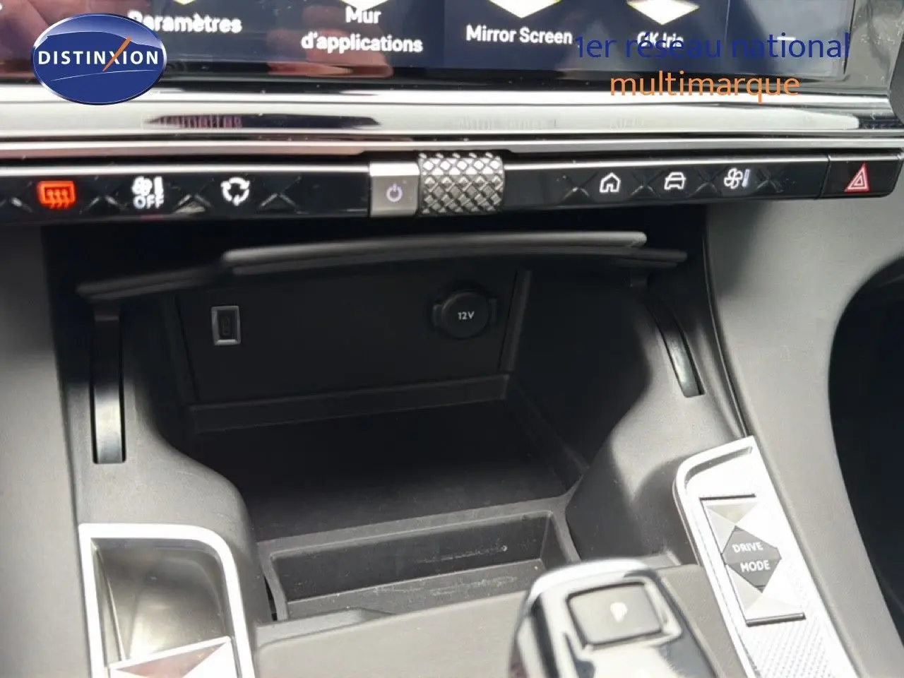 Vue rapprochée de la console centrale du DS7 2024 gris titane, montrant les commandes de climatisation et prise 12V.