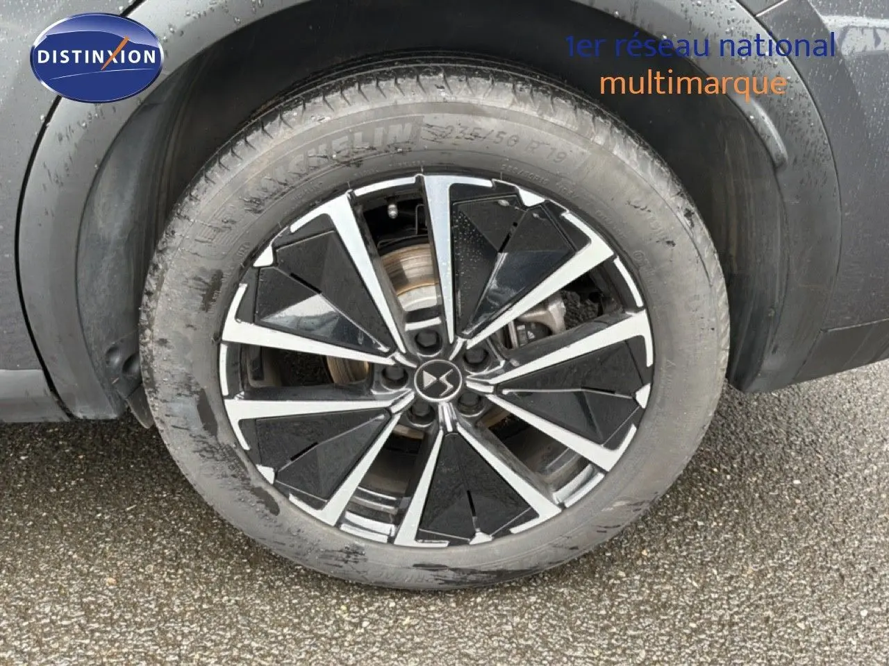 Gros plan sur la jante biton noire et argent du côté arrière droit du DS7 gris titane métal 2024.