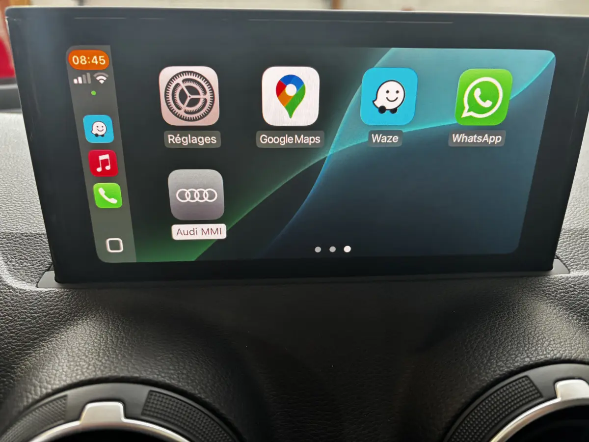 Écran central tactile de l'Audi Q2 35 TFSI S Line 2023 affichant les applications Google Maps, Waze et WhatsApp.