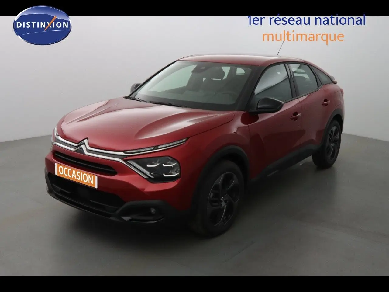 Citroën C4 rouge Elixir Metal vue 3/4 avant droit dans un studio, jantes noires et calandre distinctive.