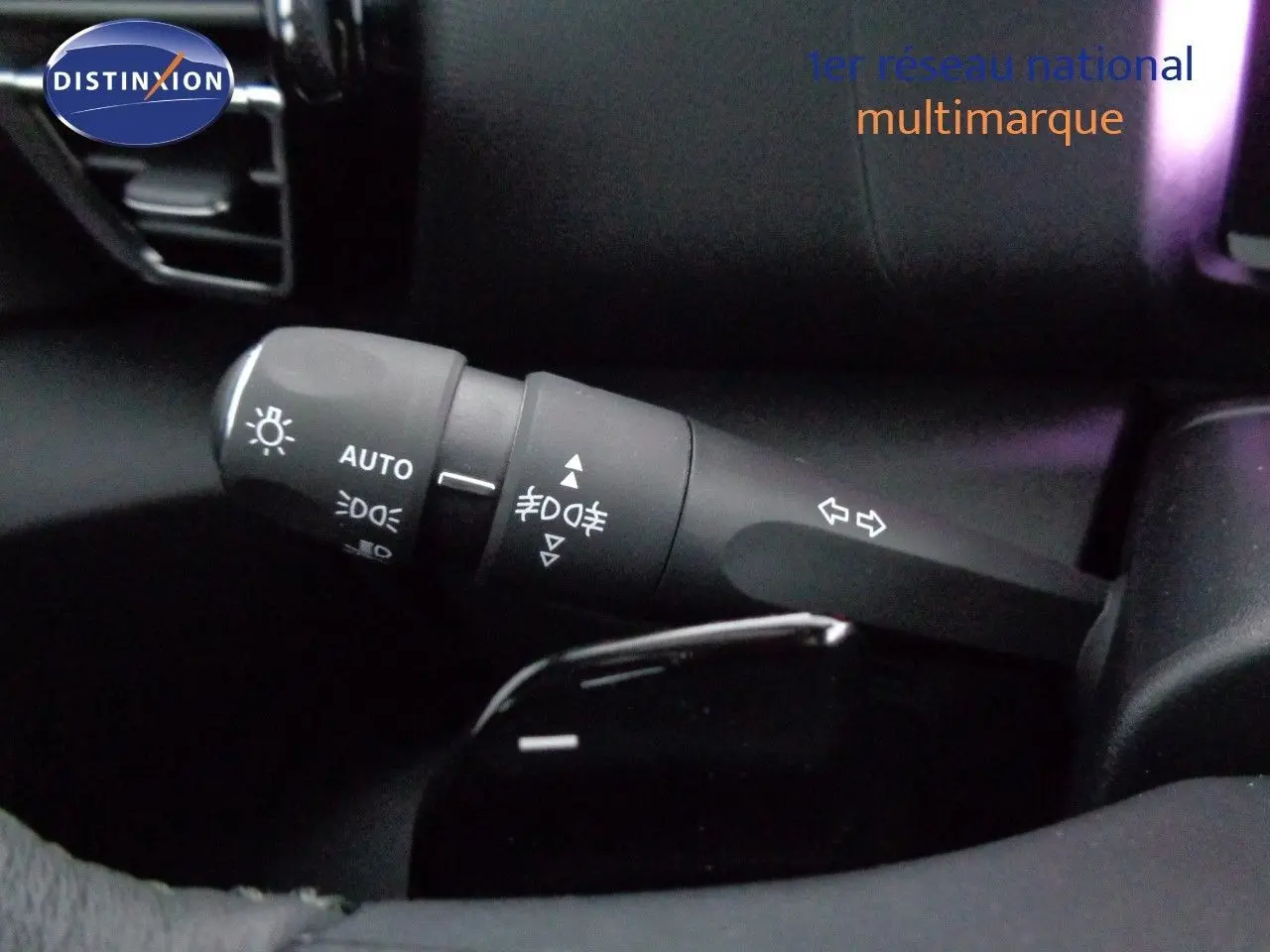 Gros plan sur la commande des feux et clignotants à gauche du volant d'une Citroën C4 rouge Elixir Metal 2023.