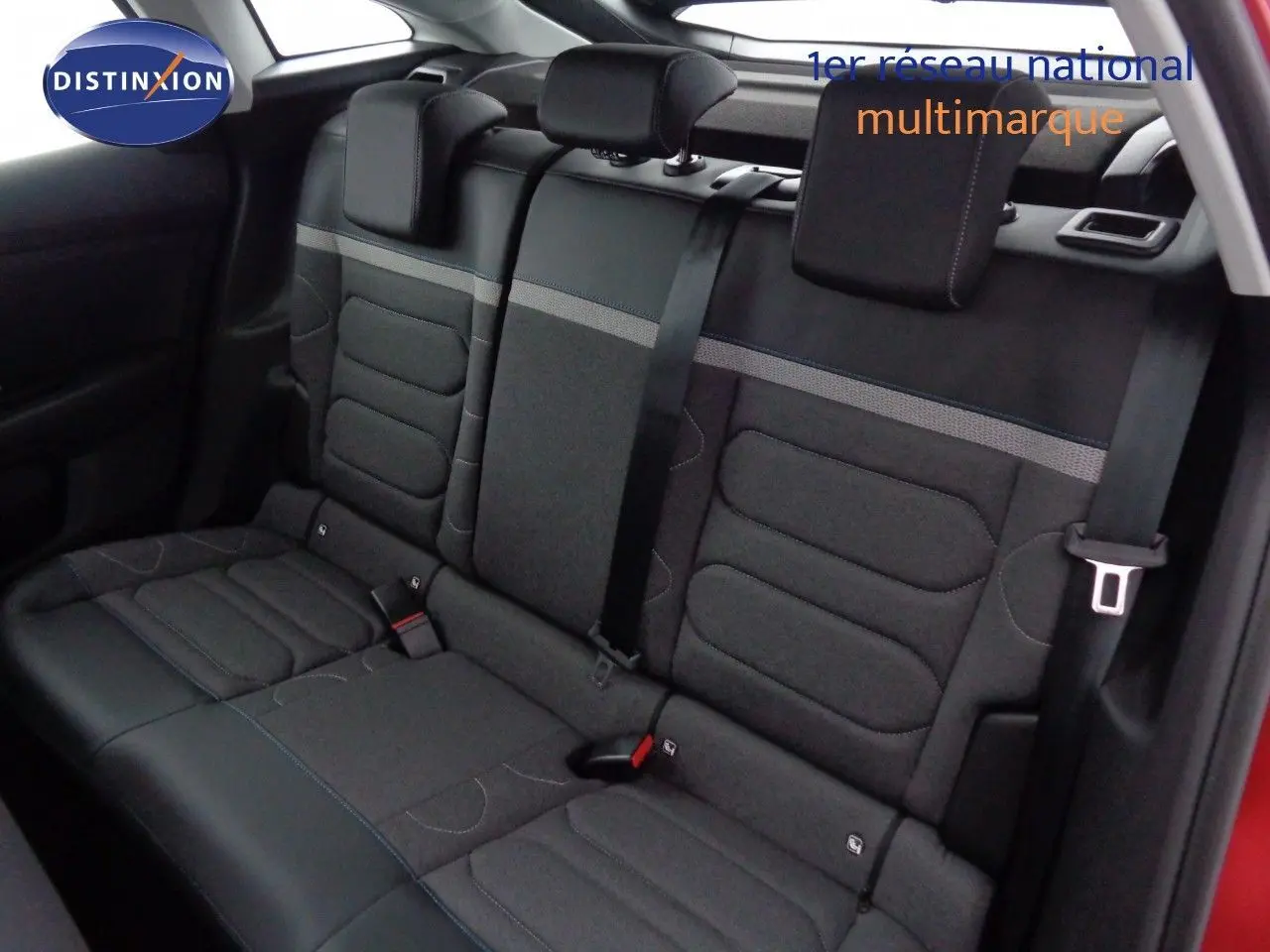 Vue intérieure sur la banquette arrière en tissu gris avec ceintures noires d'une Citroën C4 rouge Elixir 2023.