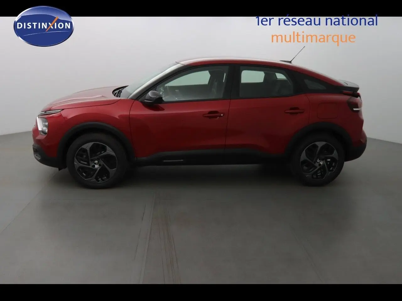 Vue de profil côté gauche d'une Citroën C4 rouge Elixir Metal 2023 avec jantes noires et toit noir contrasté.