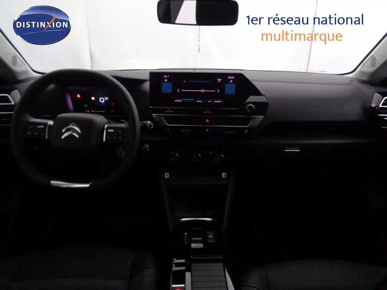Vue intérieure avant du tableau de bord et volant de la Citroën C4 2023 avec écran tactile et finition noire.