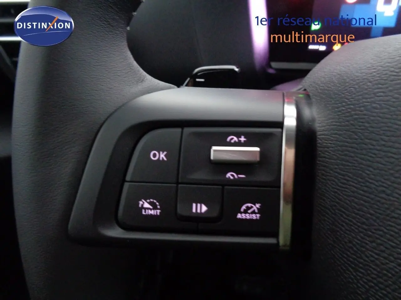 Gros plan sur les commandes au volant côté gauche de la Citroën C4 2023 en rouge Elixir Metal, boutons de régulateur et limiteur.