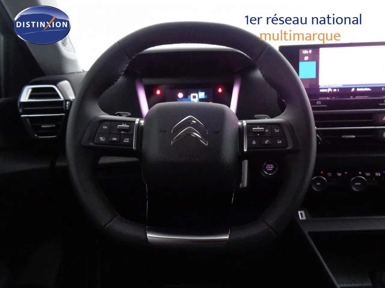 Vue rapprochée du volant multifonction noir de la Citroën C4 2023 avec tableau de bord digital et écran tactile.