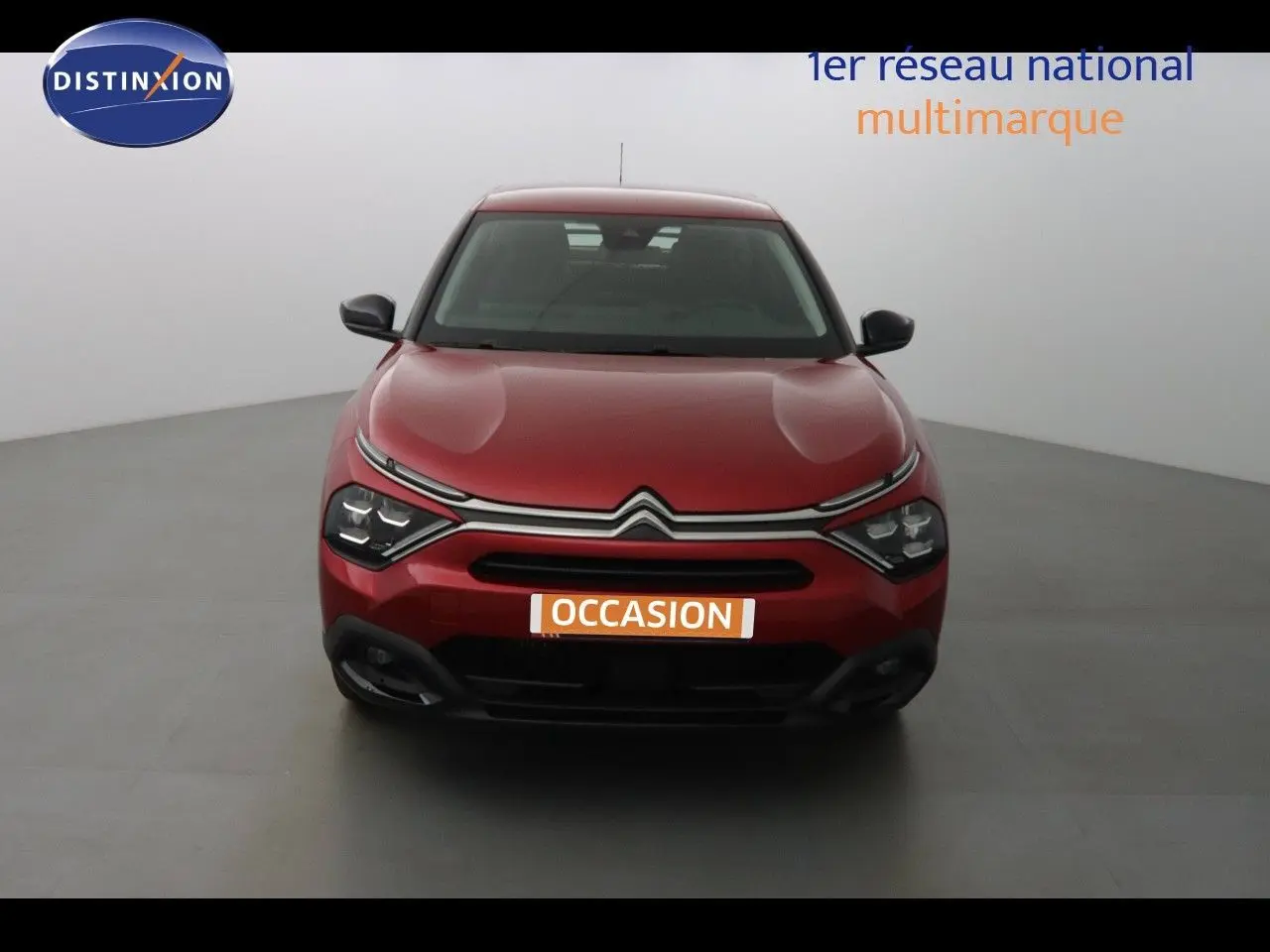 Vue frontale d'une Citroën C4 rouge Elixir Metal 2023 avec calandre distinctive et phares LED modernes.