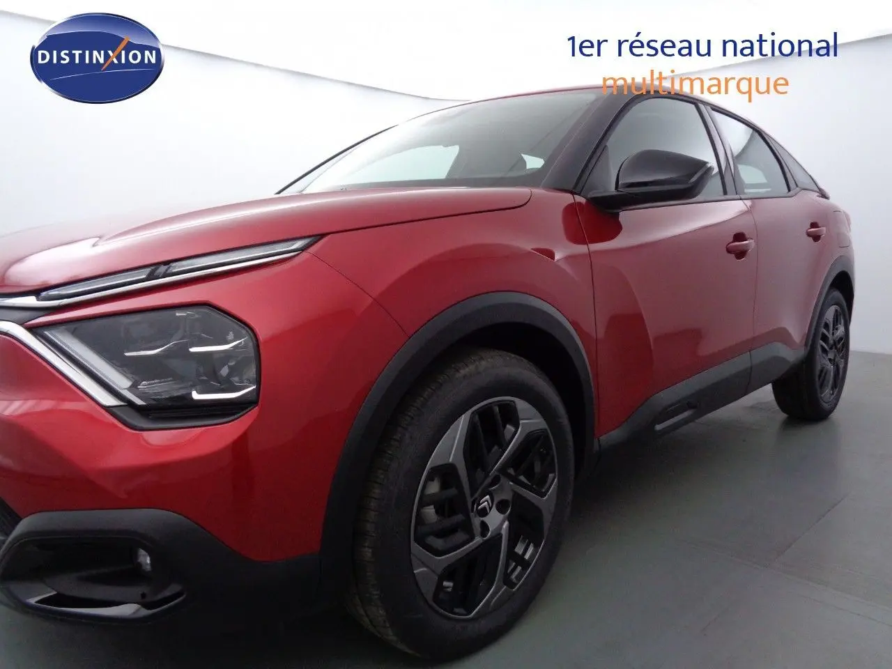 Vue 3/4 avant droit d'une Citroën C4 rouge Elixir métal avec jantes alliage et détails noirs contrastants.