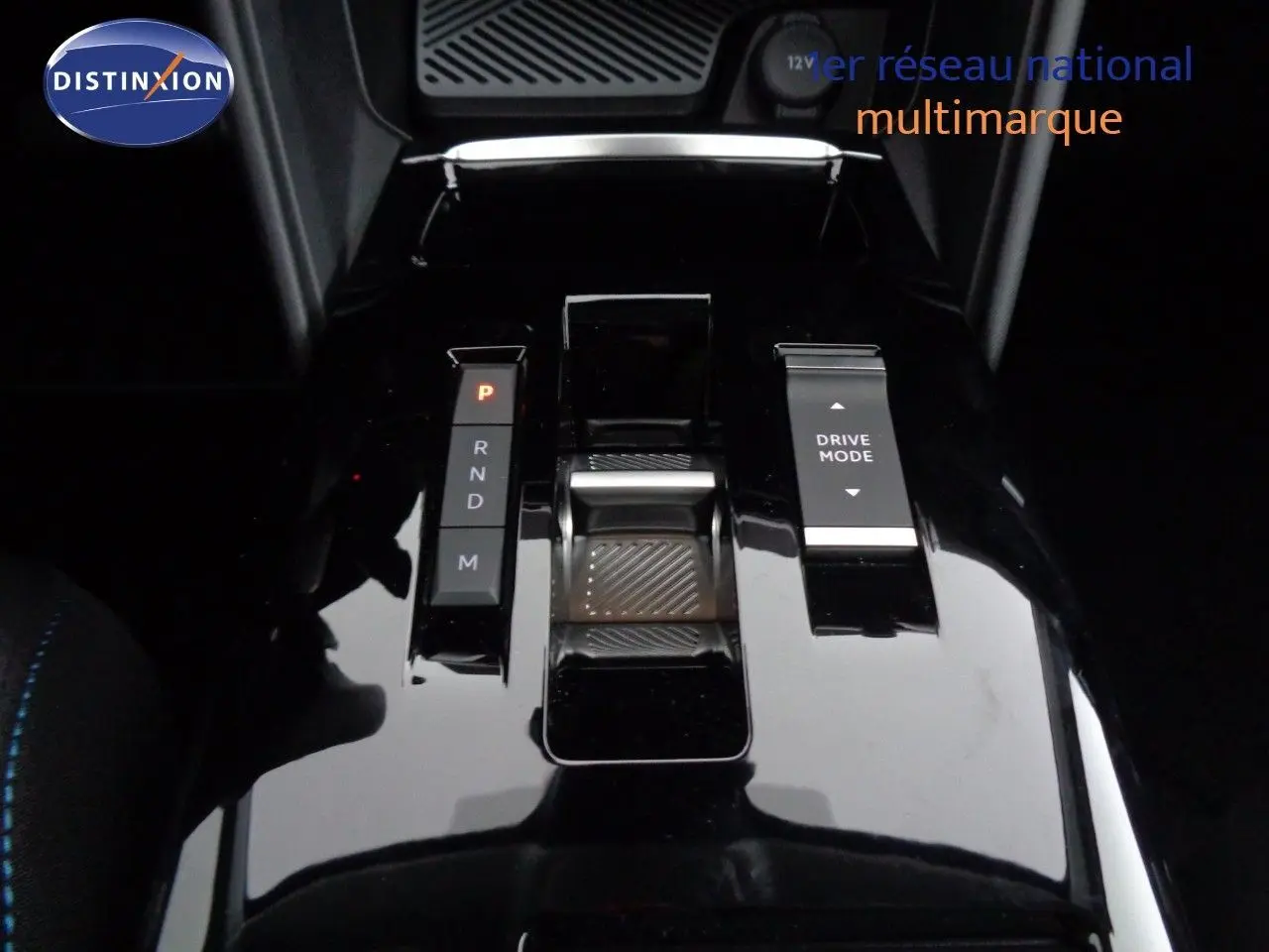 Gros plan sur la console centrale noire brillante de la Citroën C4 2023 avec sélecteur de boîte auto et bouton Drive Mode.