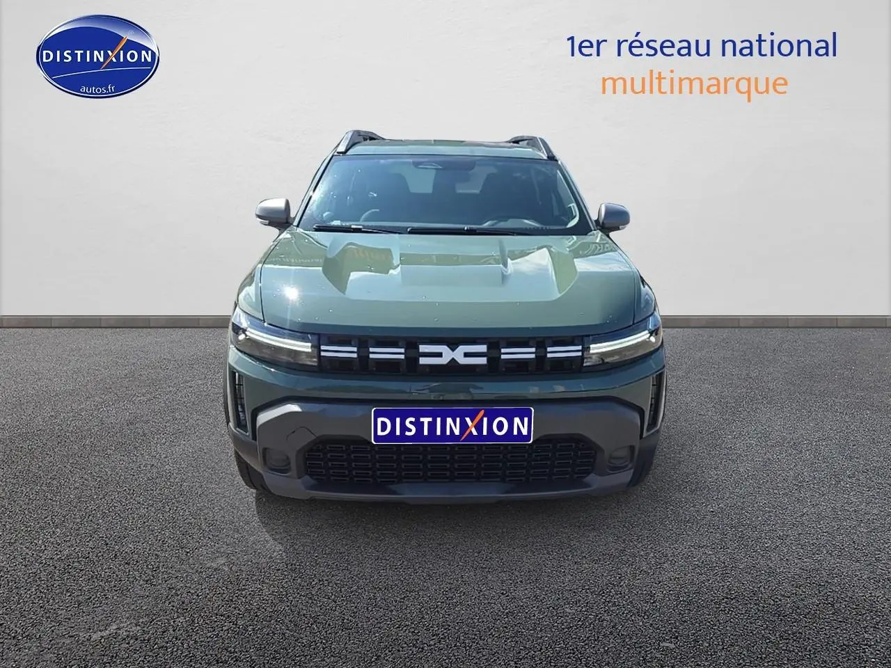 Vue avant du Dacia Duster 2025 vert kaki avec calandre noire et barres de toit visibles.