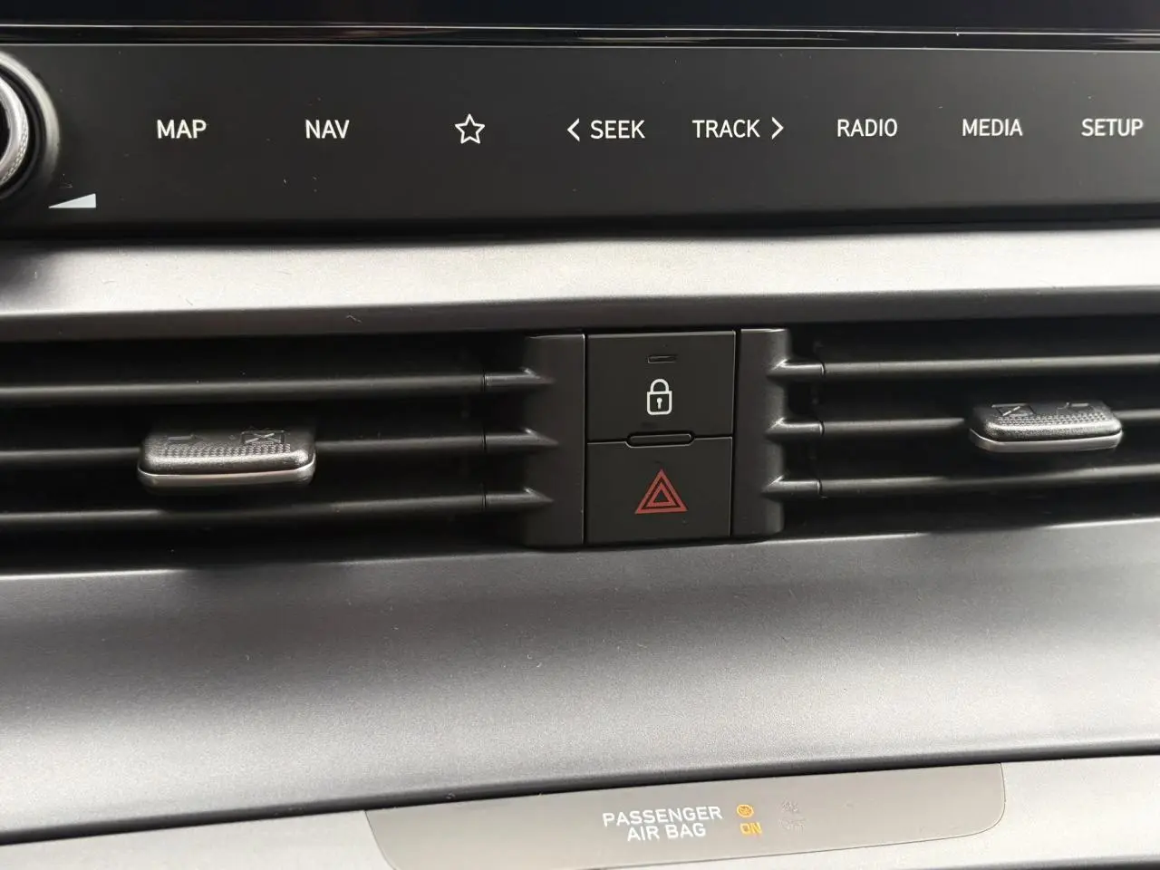 Détail du tableau de bord de la Hyundai i20 2025, montrant les aérateurs centraux et les boutons de verrouillage et warning.