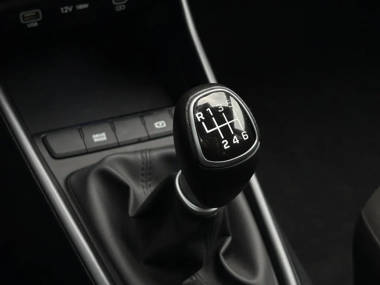 Gros plan sur le levier de vitesses manuel noir de la Hyundai i20 2025, entouré de la console centrale noire.