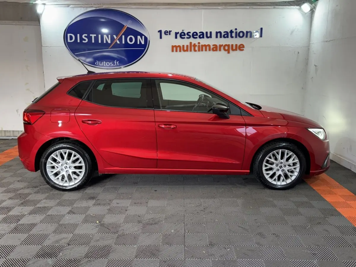 Vue latérale droite d'une SEAT Ibiza 1.0 TSI 110 FR rouge 2024, avec jantes alliage et vitres teintées.