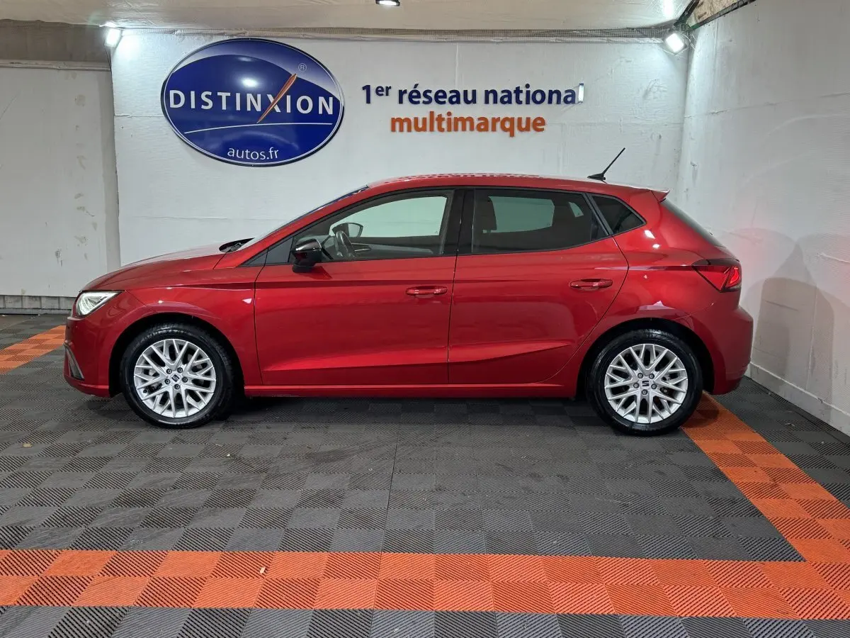 Profil droit d'une SEAT Ibiza 1.0 TSI 110 FR rouge 2024, avec jantes alliage et rétroviseurs noirs.