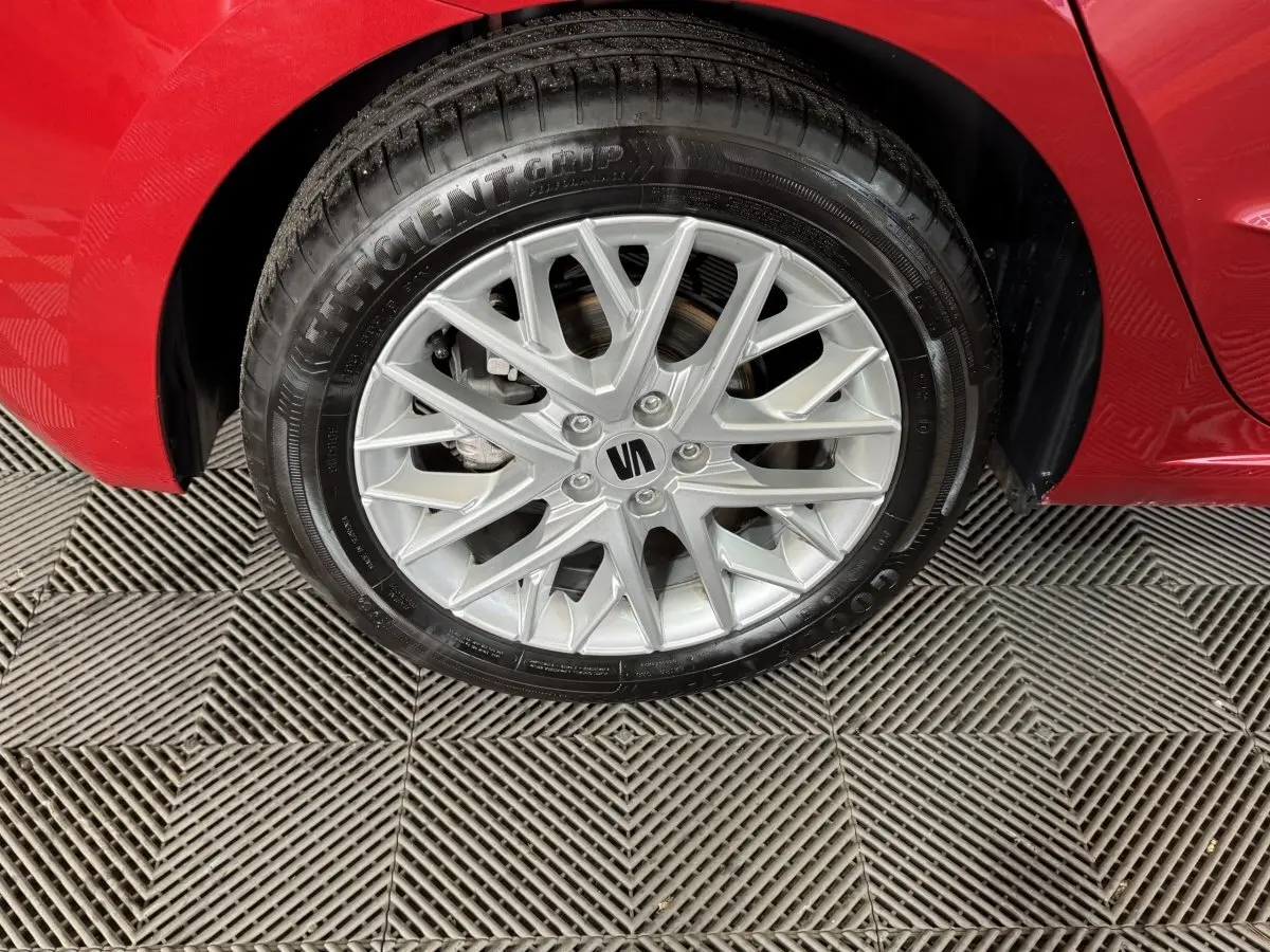 Gros plan sur la roue avant droite avec jante argentée et carrosserie rouge vif d'une SEAT Ibiza 2024.