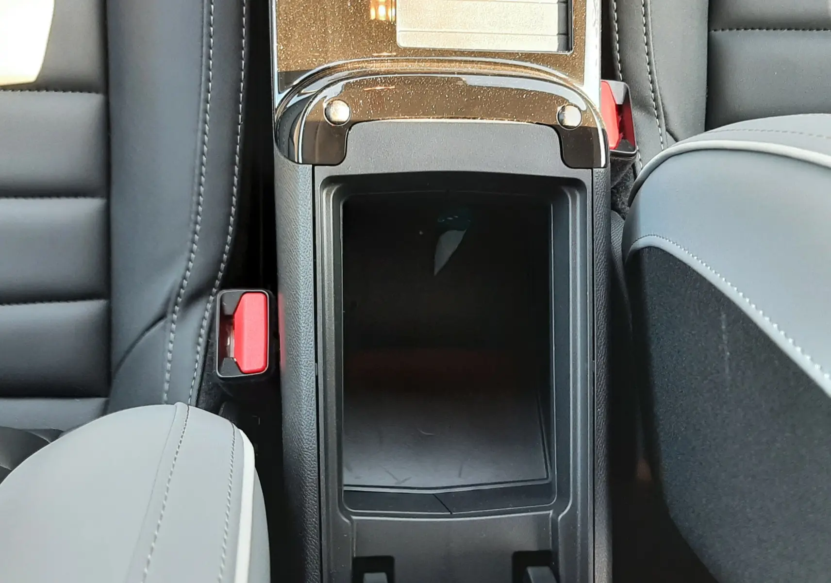 Vue plongeante sur la console centrale noire entre les sièges avant en cuir gris et noir du Citroën C4 2025.