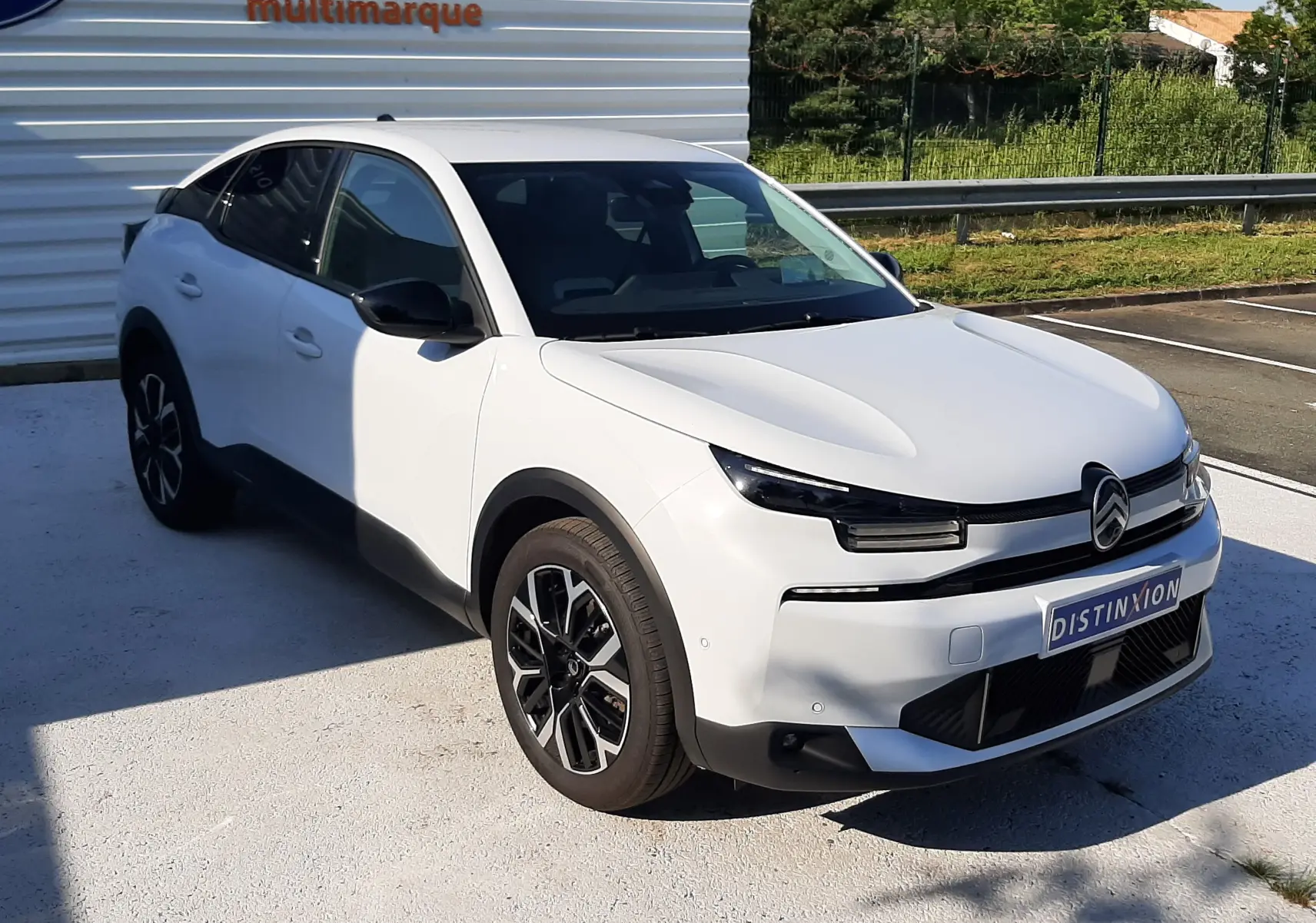 Citroën C4 blanc Okenite vue 3/4 avant droit, avec calandre distinctive et jantes bi-ton noires.