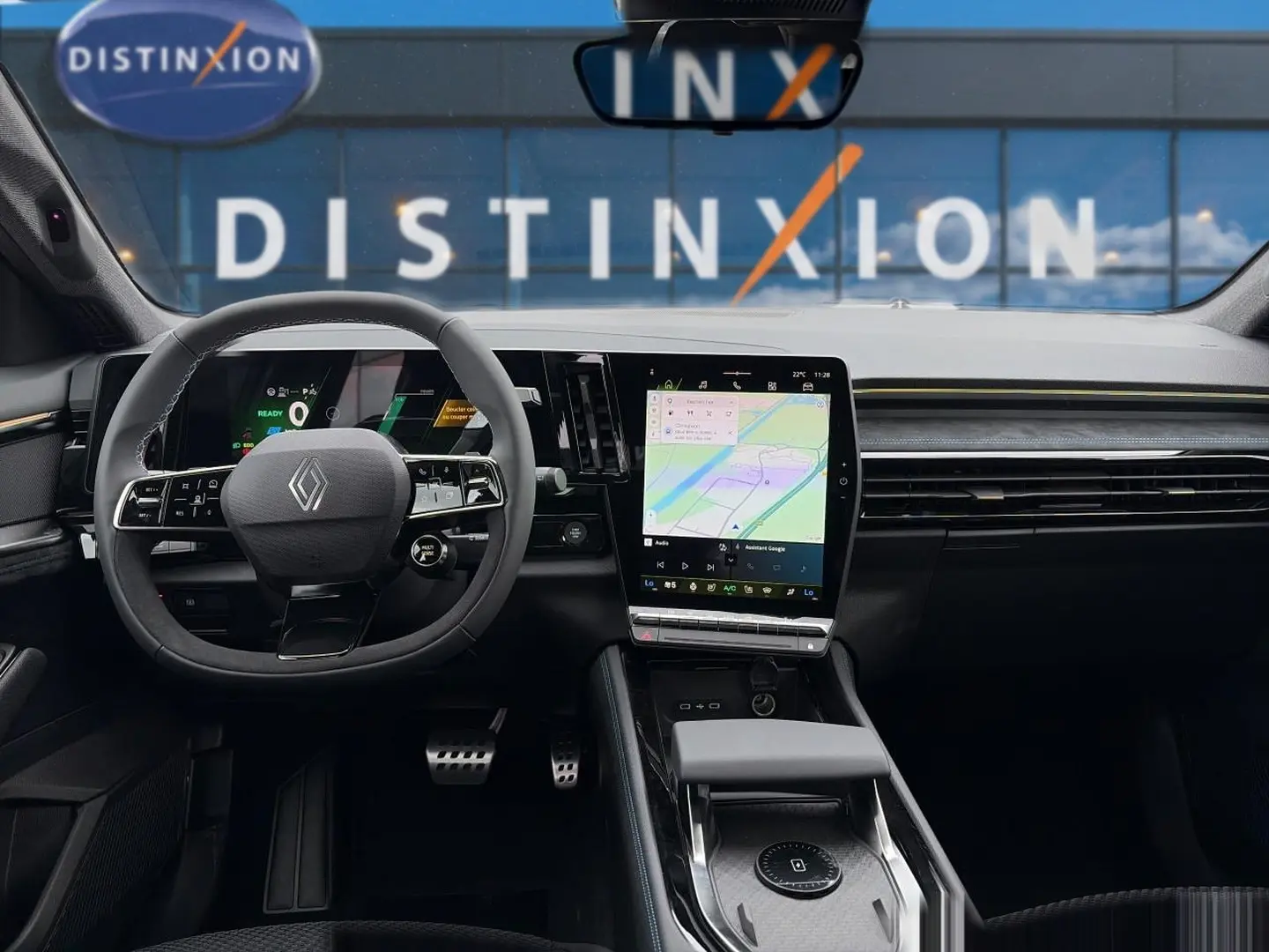 Vue intérieure frontale du Renault Austral gris schiste, avec volant multifonction et grand écran tactile central affichant la navigation.