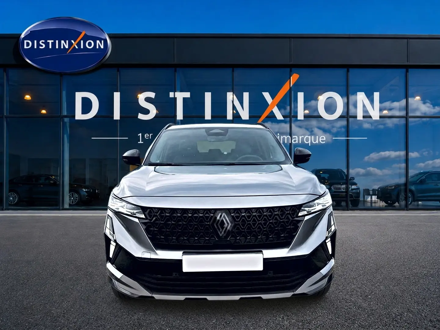 Vue avant d'un Renault Austral gris schiste avec calandre noire et logo Renault visible, devant une vitrine Distinxion.
