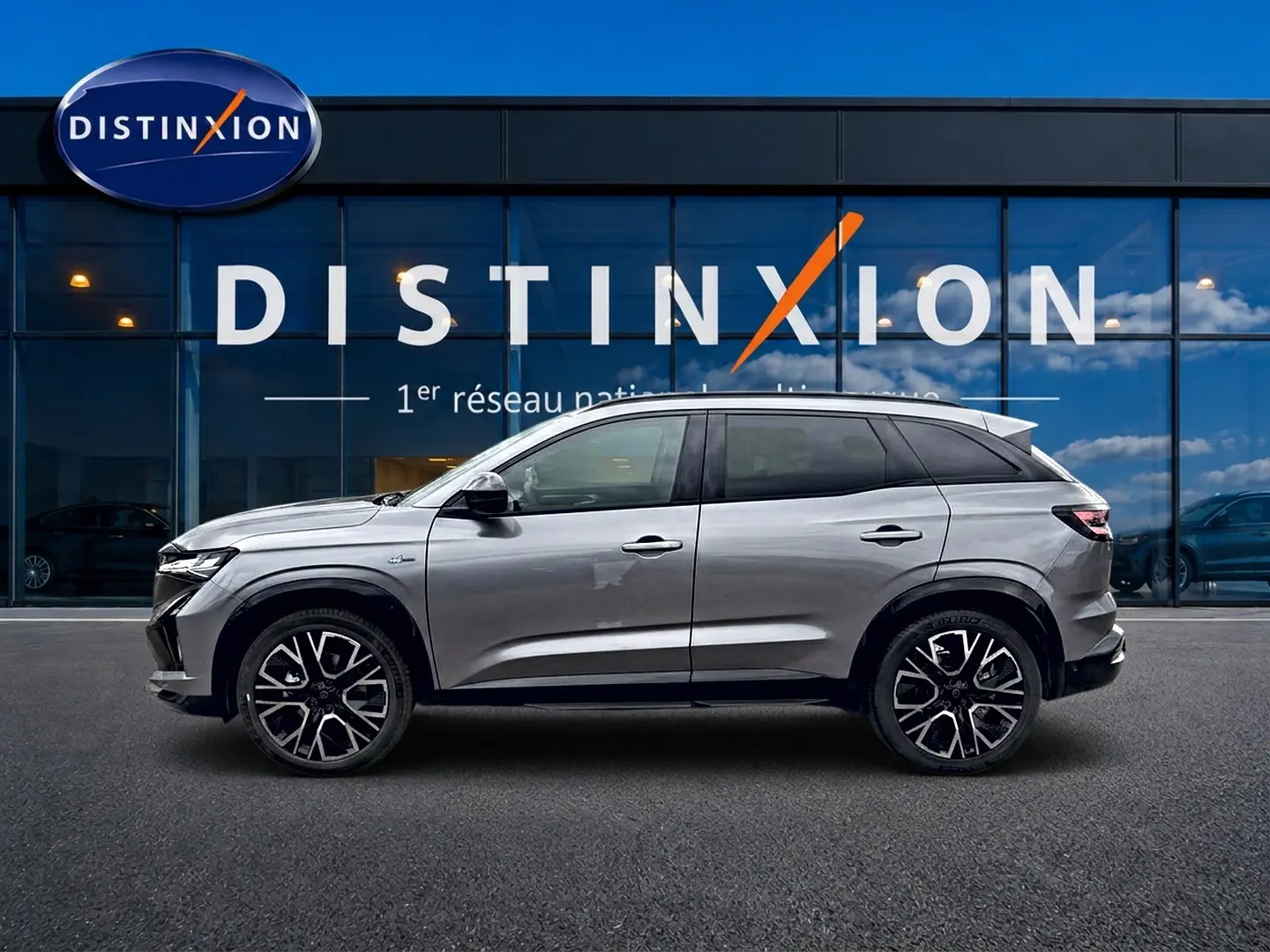 Profil droit du Renault Austral gris schiste 2026 avec jantes alliage et toit noir devant une vitrine Distinxion.