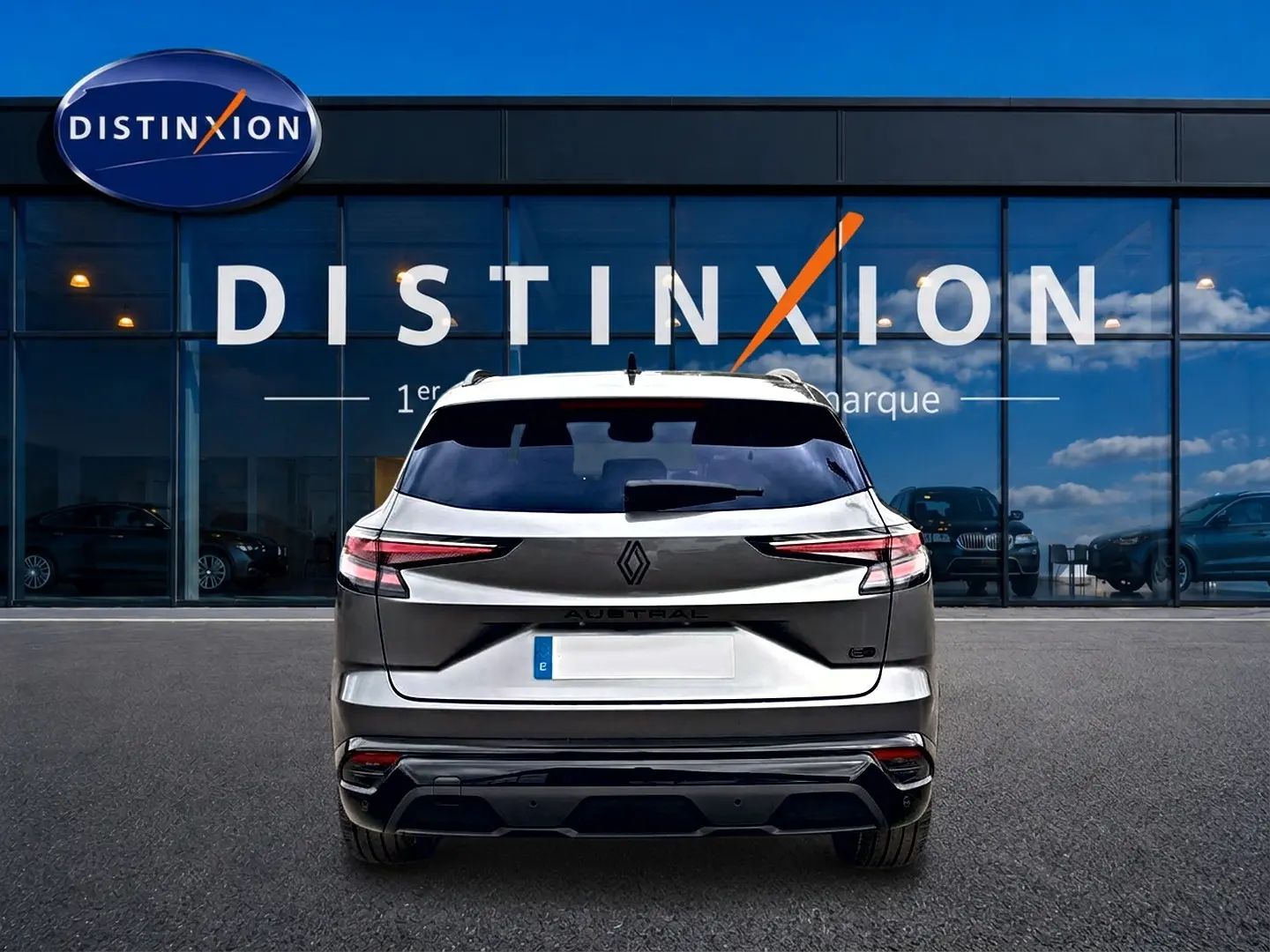 Vue arrière du Renault Austral gris schiste avec feux LED fins et toit noir, stationné devant une vitrine Distinxion.