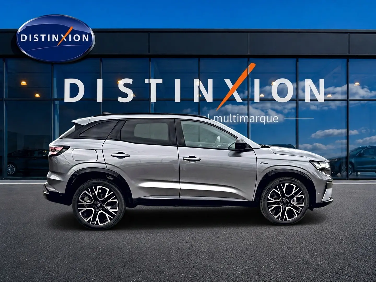 Profil droit du Renault Austral gris schiste 2026, avec jantes alu et toit noir, devant une vitrine Distinxion.