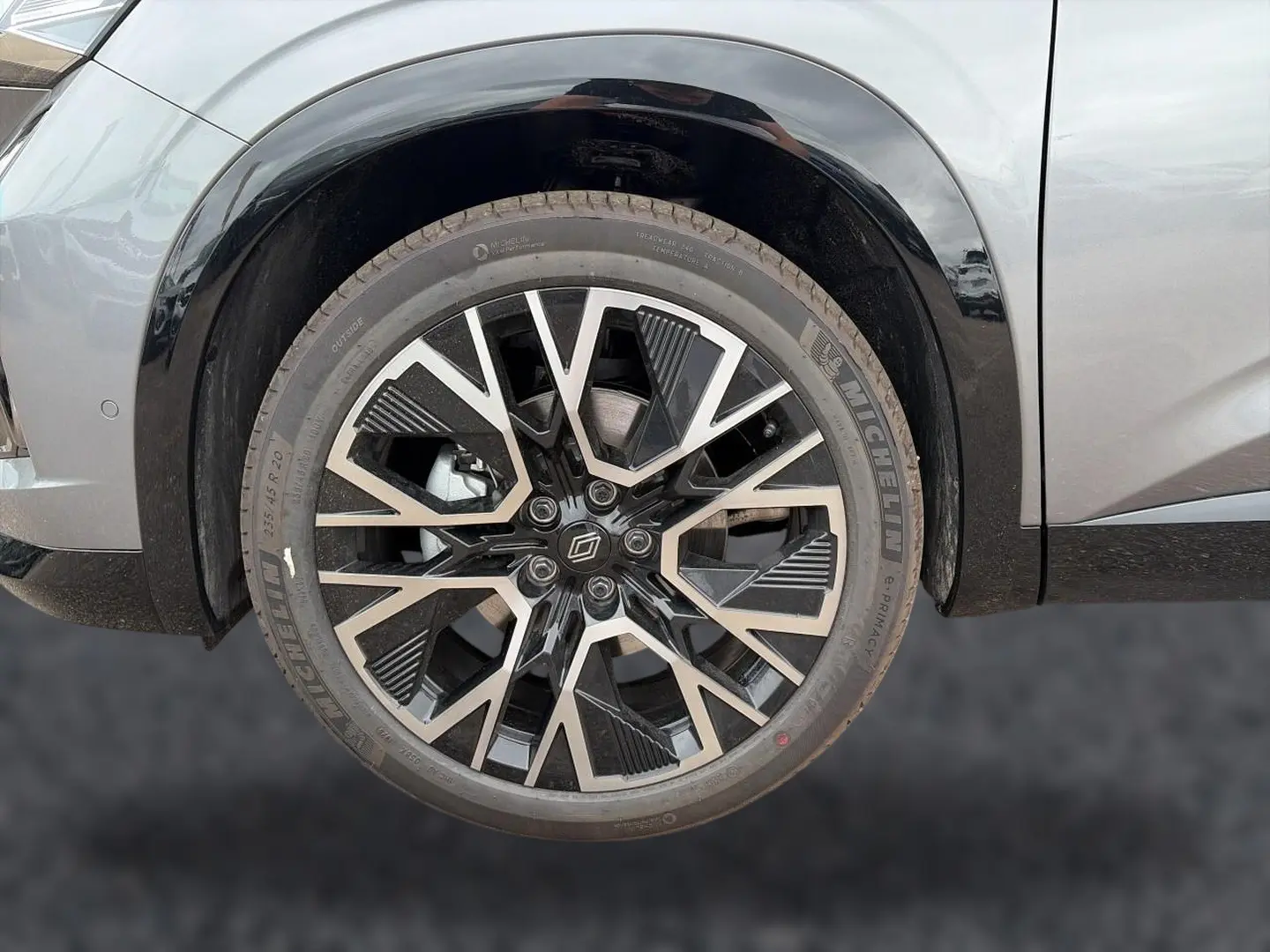 Gros plan sur la roue avant gauche du Renault Austral gris schiste avec jante alliage noire et argentée au design géométrique.