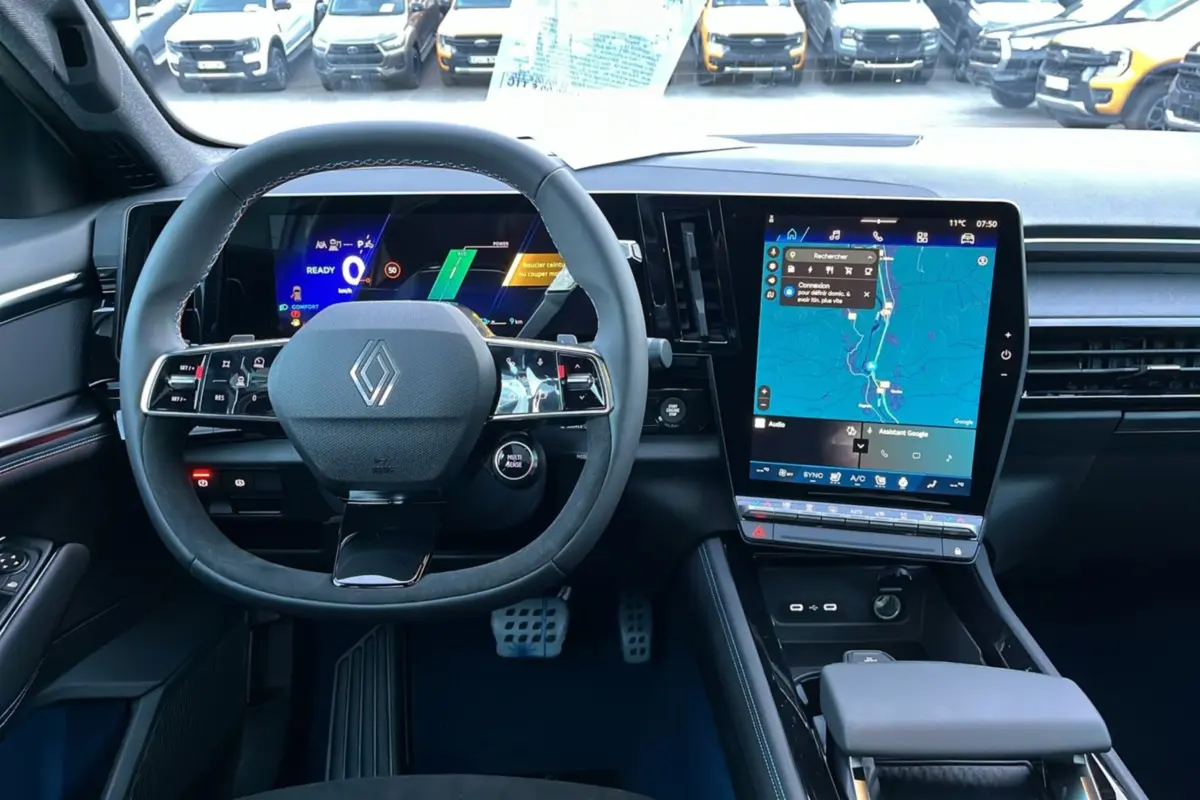 Vue intérieure avant du Renault Rafale 2025, volant cuir multifonctions et grand écran tactile central avec navigation.