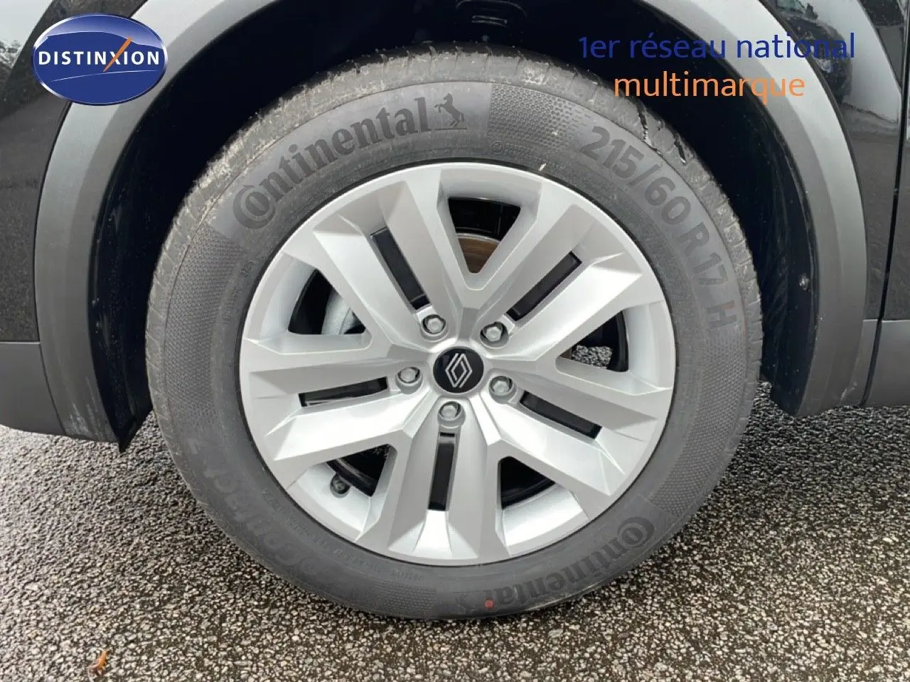 Gros plan sur la roue avant droite d'un Renault Captur noir étoile métal avec jante alliage et pneu Continental.