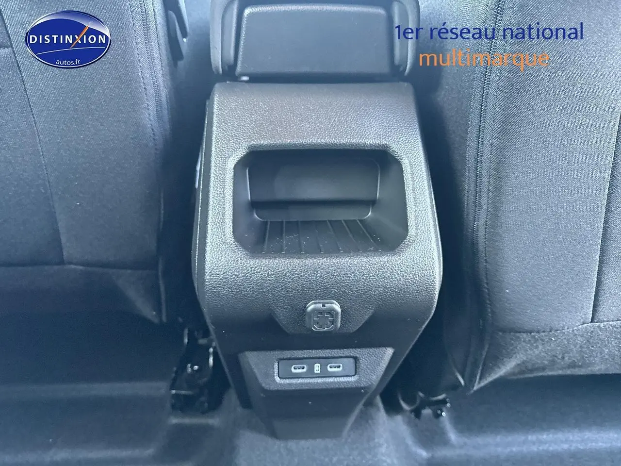 Vue rapprochée de la console centrale arrière du Dacia Duster gris schiste, avec ports USB visibles entre les sièges.