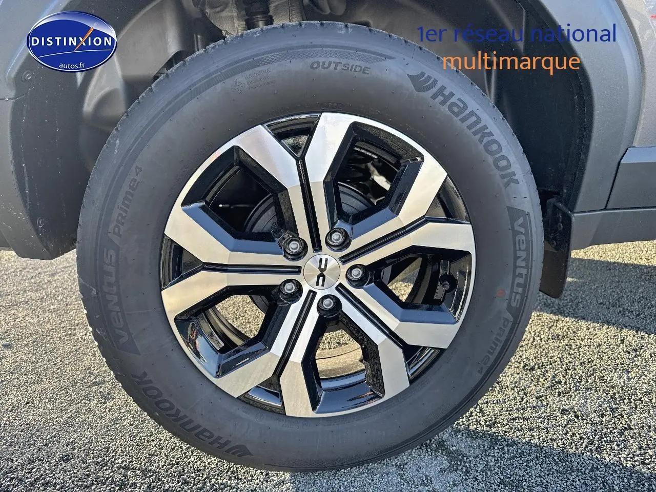 Gros plan sur la roue avant droite du Dacia Duster gris schiste avec jante alu bicolore et pneu Hankook.