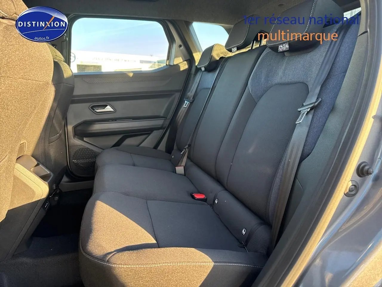 Vue intérieure côté droit de la banquette arrière noire du Dacia Duster 2025 gris schiste avec ceinture de sécurité visible.