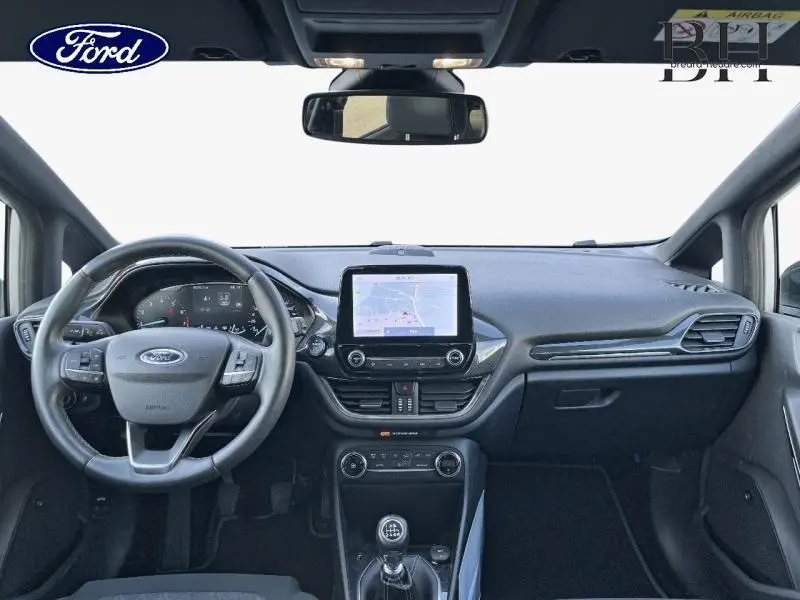 Vue frontale de l'habitacle gris de la Ford Fiesta 1.0 EcoBoost 2020 avec écran tactile et volant cuir.