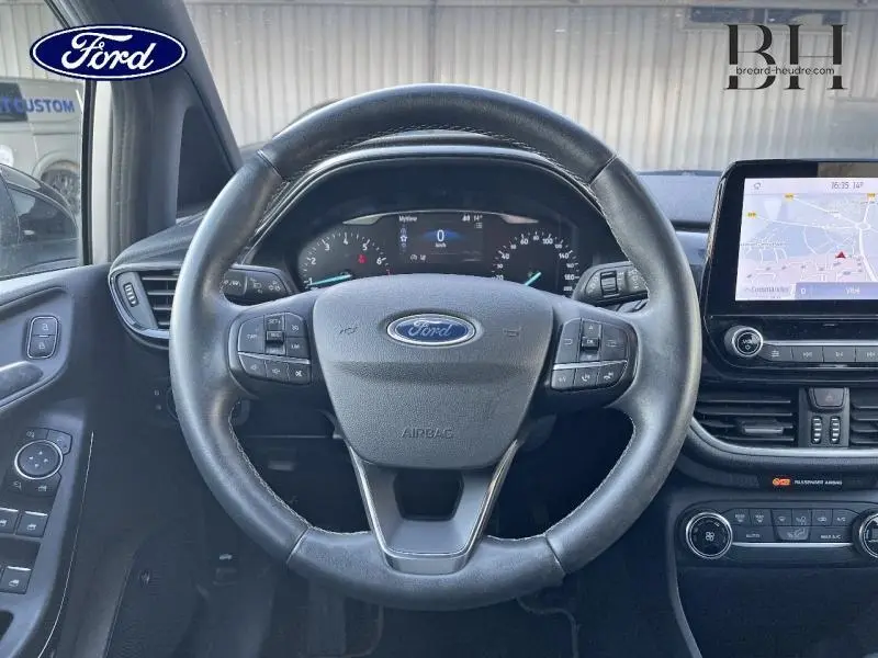 Vue centrée sur le volant cuir noir de la Ford Fiesta 2020 avec tableau de bord numérique et écran tactile GPS.