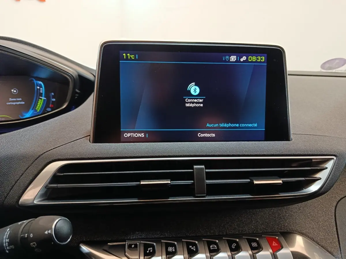 Vue rapprochée de l'écran tactile central et des aérateurs du tableau de bord du Peugeot 3008 bleu hybride rechargeable.