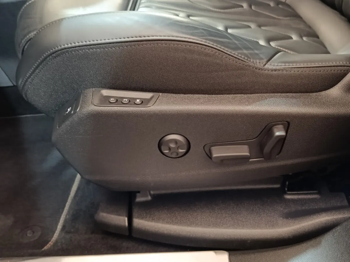 Détail des commandes de réglage électrique du siège avant noir du Peugeot 3008 hybride rechargeable bleu.