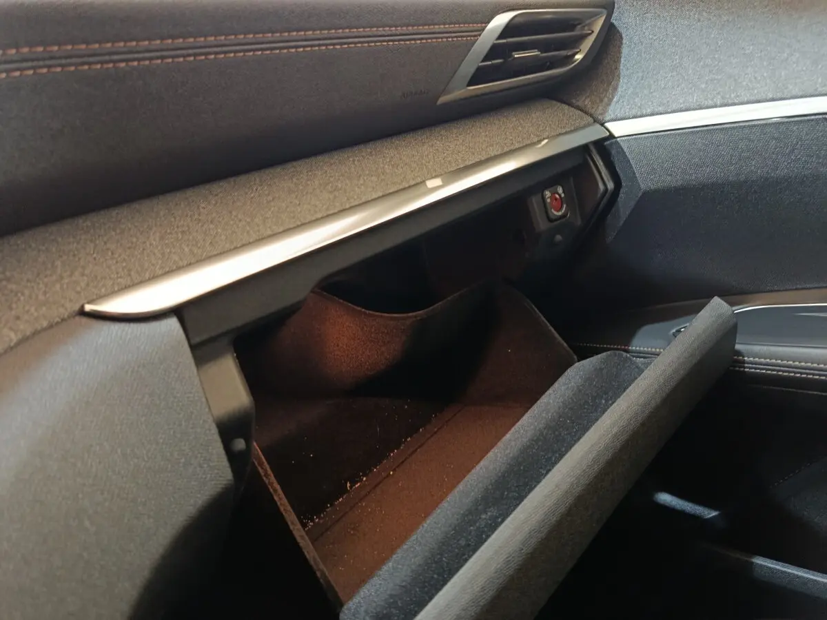 Intérieur du Peugeot 3008 GT Pack 2020, vue sur la boîte à gants ouverte avec finition tissu noir et surpiqûres marron.