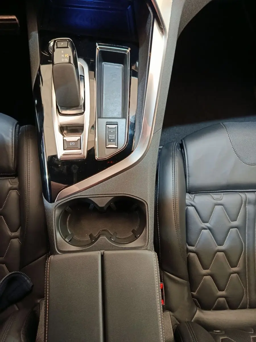Vue plongeante sur la console centrale noire et le levier de vitesses du Peugeot 3008 GT Pack avec sièges cuir noirs.