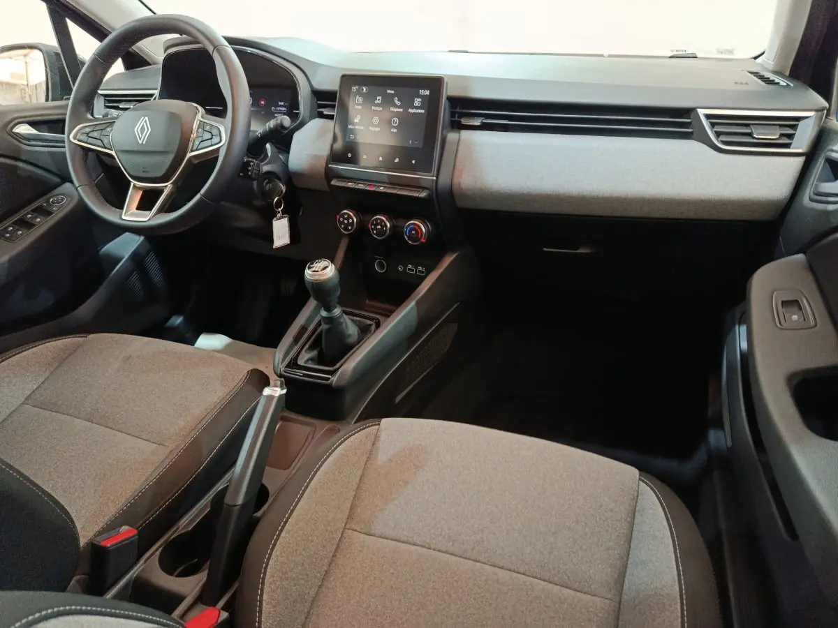Vue intérieure avant droite de la Renault Clio noire 2025, montrant le volant, la boîte manuelle et l'écran tactile central.
