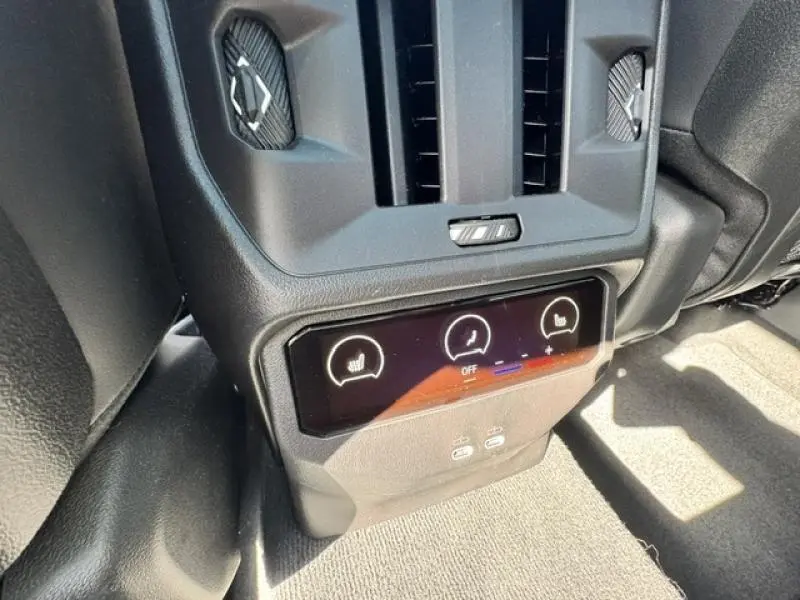 Gros plan sur la console arrière noire du BMW X3 2024 avec commandes tactiles de sièges chauffants et ports USB.