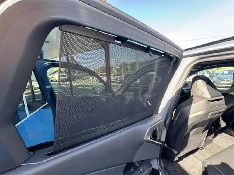 Vue intérieure côté arrière droit d’un BMW X3 xDrive20 2024 avec pare-soleil en filet et sièges sport Alcantara noirs.
