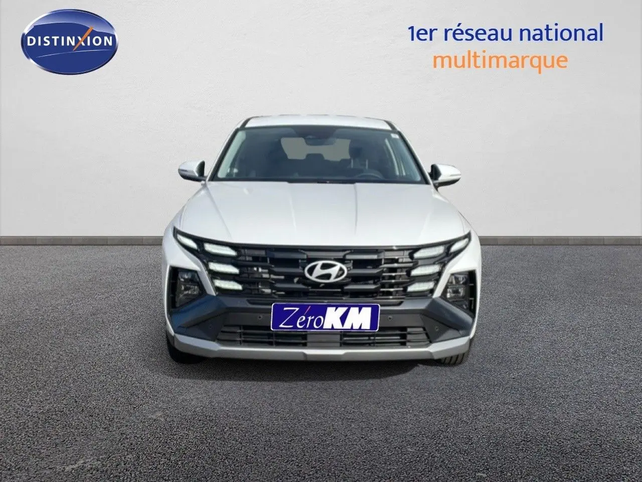 Vue frontale d'un Hyundai Tucson blanc Atlas 2026 avec calandre noire distinctive et phares LED intégrés.