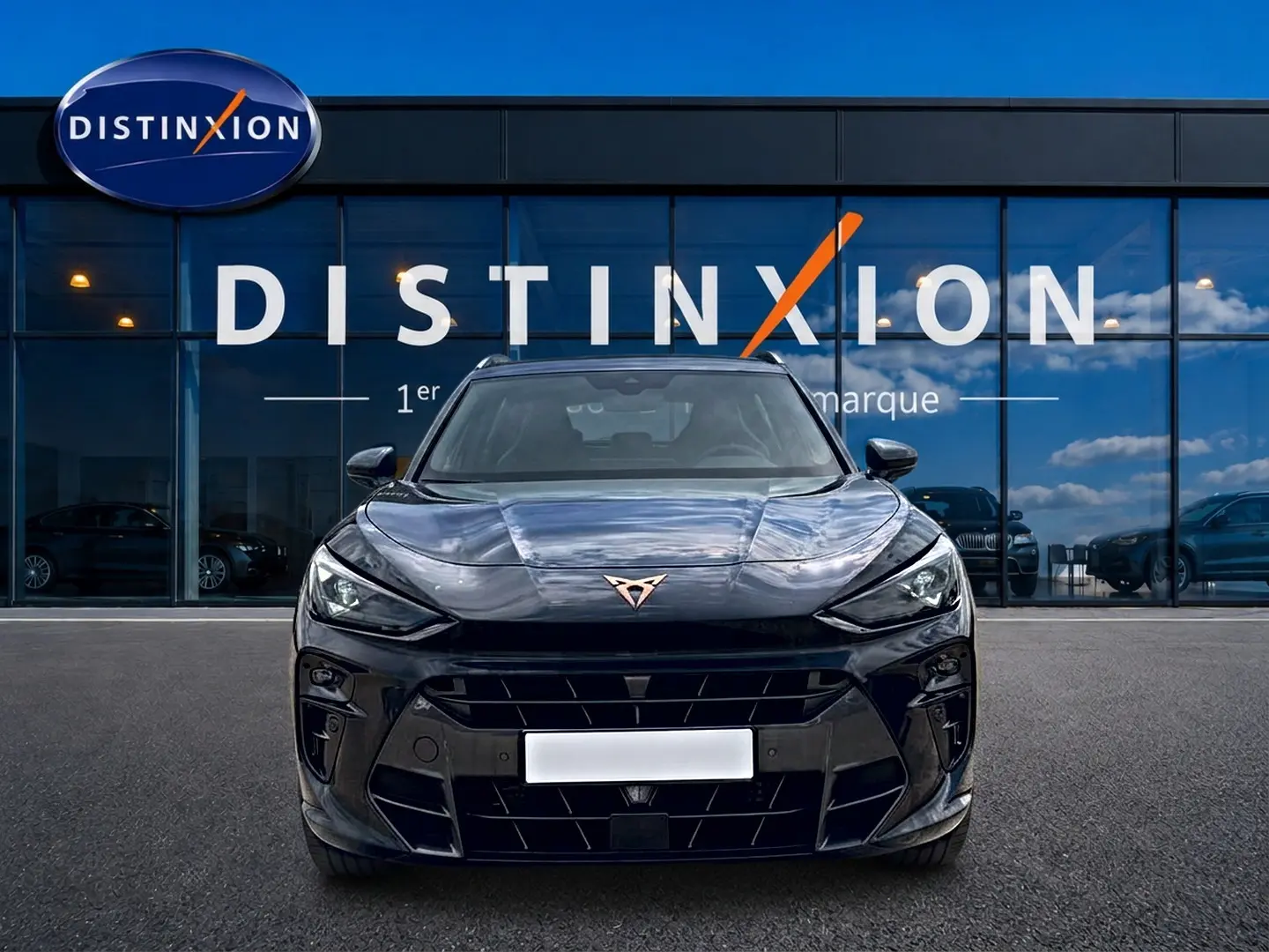 Vue frontale d'un CUPRA TERRAMAR gris timanfaya avec calandre marquée et logo cuivré, devant une vitrine Distinxion.