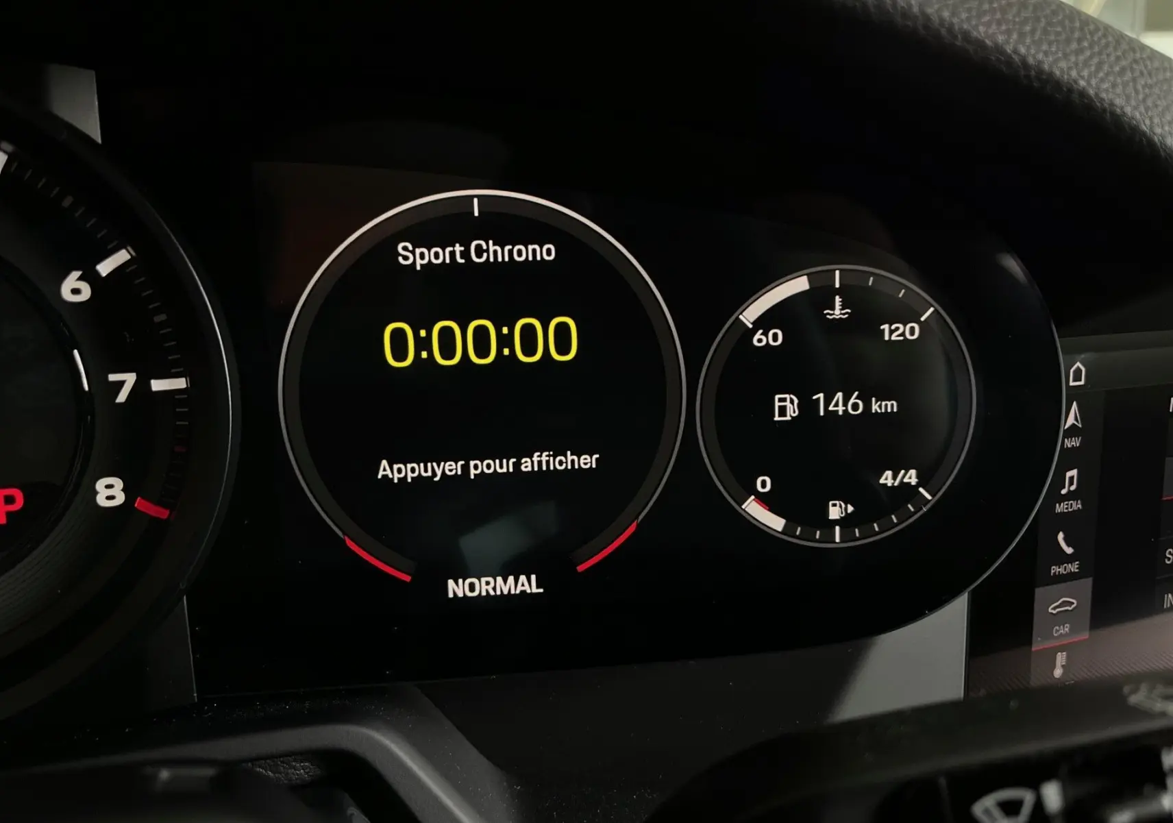 Gros plan sur le tableau de bord numérique de la Porsche 911 Carrera S 2019 avec affichage Sport Chrono et autonomie de 146 km.