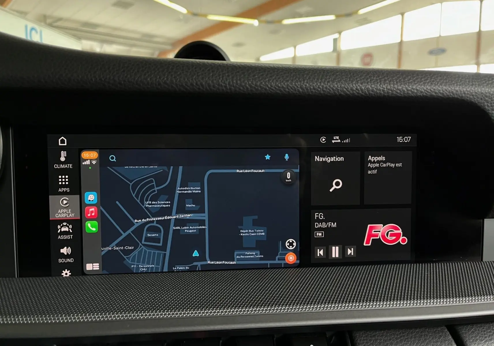 Écran central tactile du tableau de bord de la Porsche 911 argent, affichant la navigation et les appels Apple CarPlay.