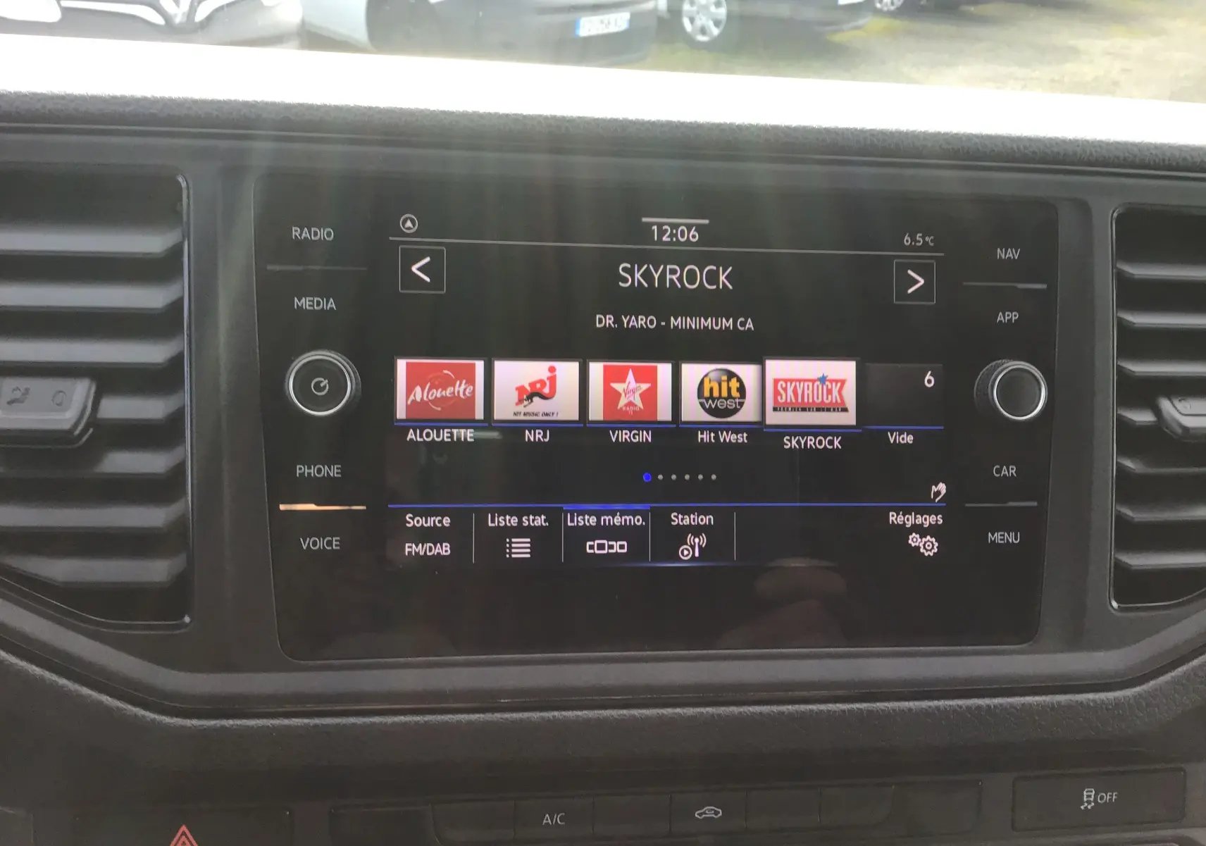 Écran tactile multimédia du Volkswagen Crafter blanc 2021 affichant les stations radio dont Skyrock, vue intérieure centrale.